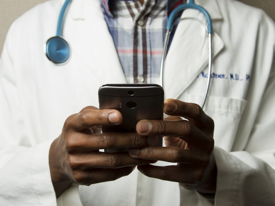 Soignant en tenue, stéthoscope, outil de suivi à portée de main